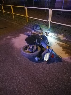 motocykl leży na ulicy w tle barierki ochronne