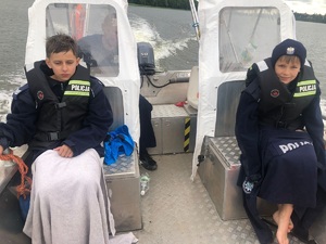 Policjant z dziećmi na łodzi
