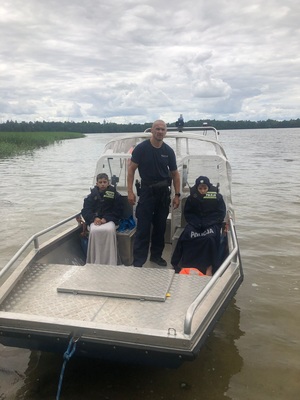 Policjant z dziećmi na łodzi